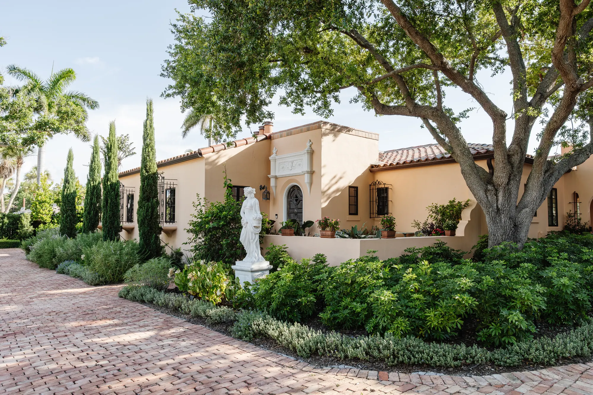 Restored Mediterranean house on St. Armands Circle, Sarasota — live oak, barrel tile, brick court
